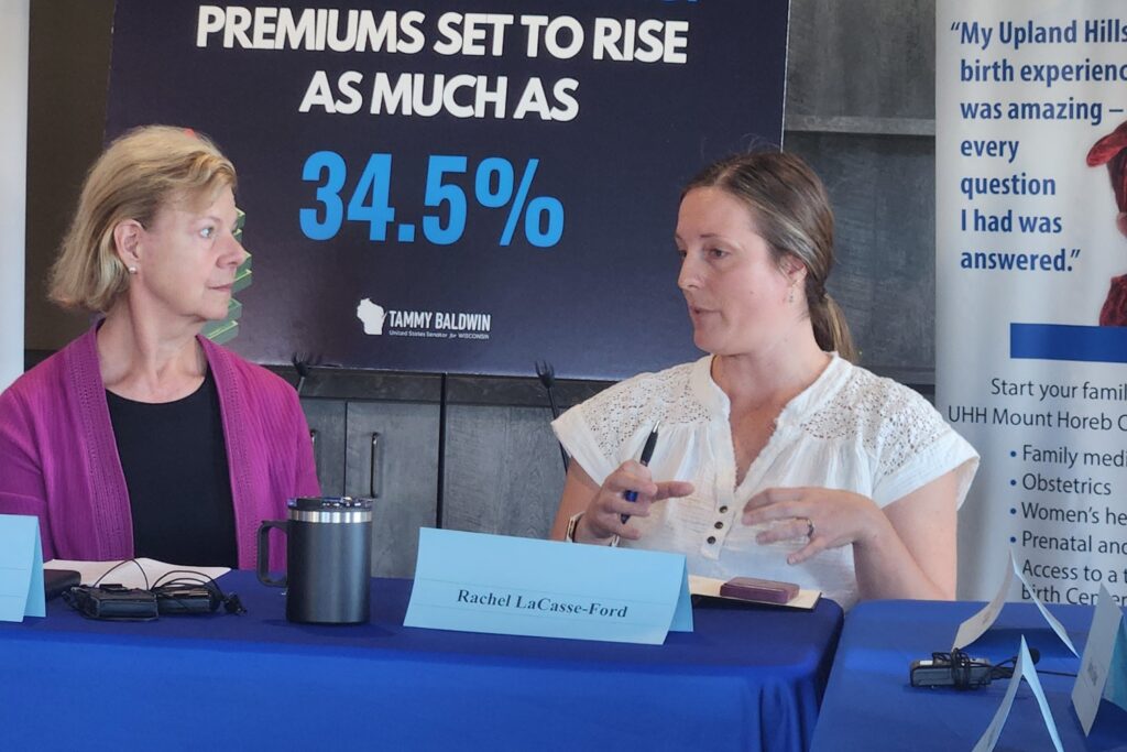 Rachel LaCasse-Ford, right talks to Sen. Tammy Baldwin about her use of the Affordable Care Act marketplace to buy insurance during a meeting Baldwin held with small business owners and others in Mount Horeb, Wisconsin, on Sept. 25.