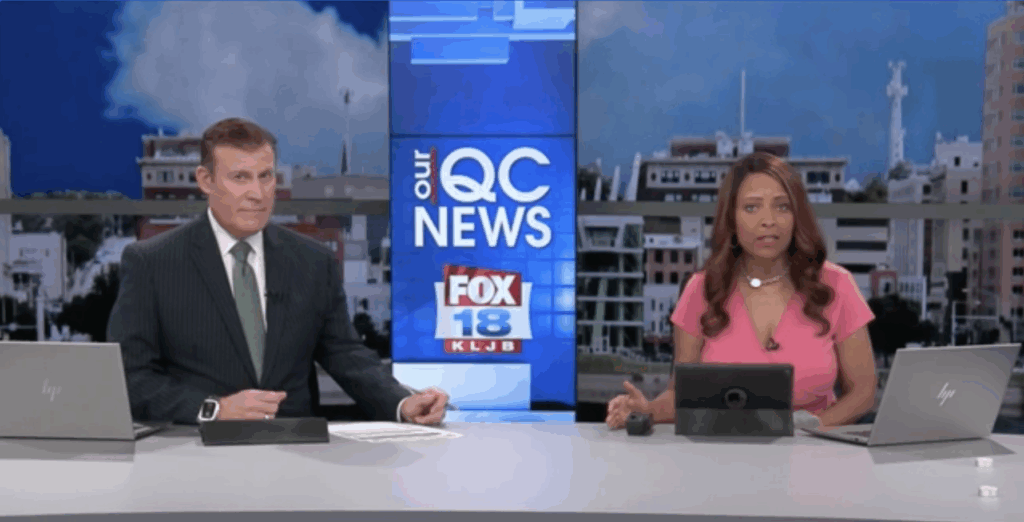 News anchors sit at a desk, with OUR QC News, Fox 18 KLJB screen behind them