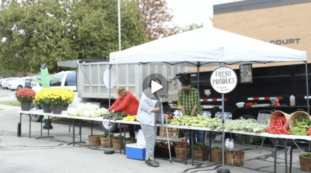 A woman in front of a fresh produce stand