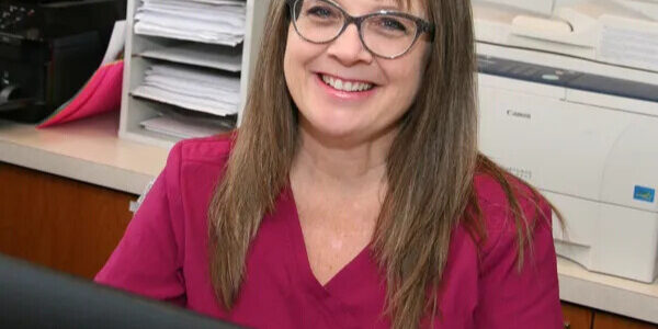 Chrysa Ostenso smiling at her desk
