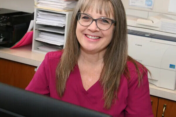 Chrysa Ostenso smiling at her desk