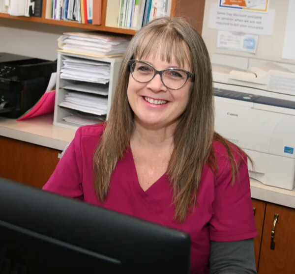 Chrysa Ostenso smiling at her desk