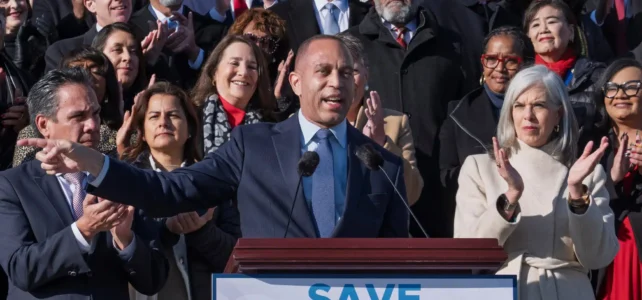 Hakeem Jeffries in front of a podium that reads save healthcare