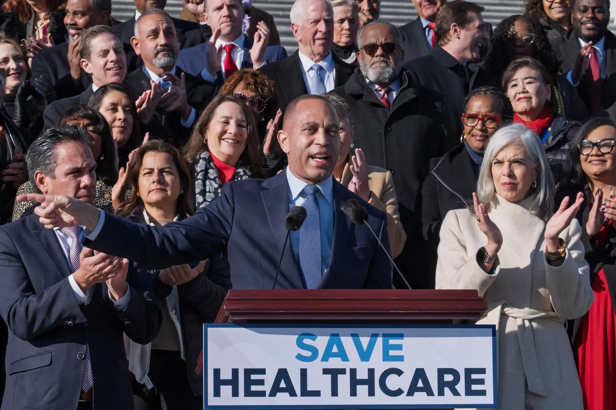 Hakeem Jeffries in front of a podium that reads save healthcare